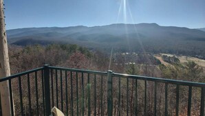 Un balcone con vista su montagne lontane e un cielo sereno.