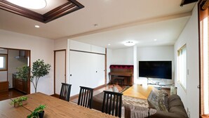 A modern living room with a dining area, a television, and a piano. - Private whole-house stay in a quiet area of Shinoro, Sapporo. 3 bedrooms, up to 6 guests (札幌市)