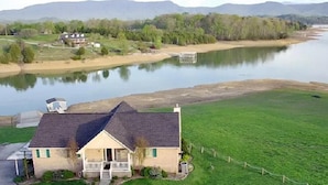 A house with a sloped roof, a porch, and a fenced yard. - Three Horizons Retreat (Dandridge)