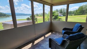 A balcony with wicker chairs and a view of a lake and mountains. - Three Horizons Retreat (Dandridge)
