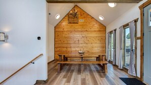 Ein Holzinnenraum mit einer Bank, Holzwänden und einer Chandelüstere.