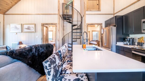 A spacious kitchen with a central island, a built-in stove, and a modern refrigerator. - Suite Retreat (Pigeon Forge)