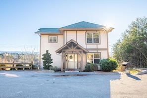 A two-story house with a front porch, a garage, and a driveway. - Birdies and Bearcubs (Pigeon Forge)