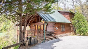 A log cabin with a porch, a covered deck, and a stone foundation. - Z - Bear Ridge (Gatlinburg)