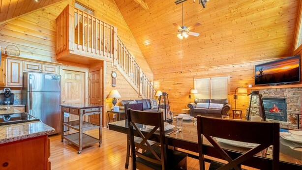 A cabin interior with a kitchen, dining area, living room, and fireplace. - Z - Bear Ridge (Gatlinburg)