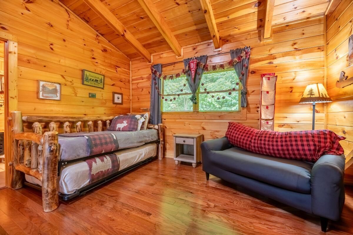Ein Blockhaus-Interieur mit einer Couch, einer Bank und einem kleinen Tisch.