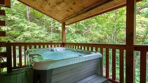 A hot tub on a wooden deck with a forest view. - Timber Tails (Sevierville)