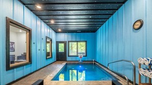 A spa room with a pool, a clock on the wall, and a towel rack. - Smoky Mountain Sapphire (Pigeon Forge)