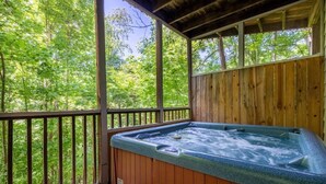 Ein Whirlpool auf einer Holterrasse mit Blick auf einen Wald.