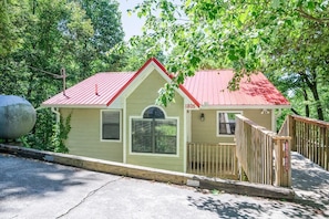 A small, single-story building with a red roof, a white door, and a small porch. - Z - Four Cubs Cottage (Sevierville)