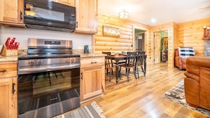 A log cabin interior with a kitchen, dining area, and living room. - Oldham Ridge Retreat (Sevierville)