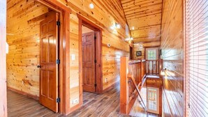Ein Holzblock-Interieur mit einer Holztreppe, Holztüren und einem kleinen Fenster.