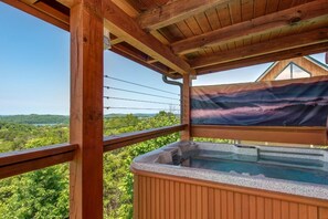 A wooden deck with a hot tub, a view of the landscape, and a mountain painting. - Lakeview Serenity (Sevierville)