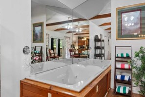 A bathroom with a large bathtub, wooden vanity, and a mirror. - Mountain Dew (Gatlinburg)