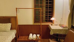 A room with a wooden bed, a small table with a lamp, and a window with a view. - Cozy Room in the Quiet Space of Hue (Thành phố Huế)
