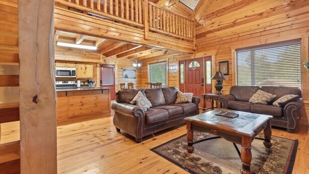 Ein Holzhaus-Interieur mit Wohnzimmer, Küche und Essbereich.