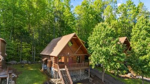 Eine Holzhütte mit Veranda und einer Treppe, die zu einer Terrasse führt.