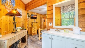 Un interior de madera con una televisión, una chimenea y un espejo grande.