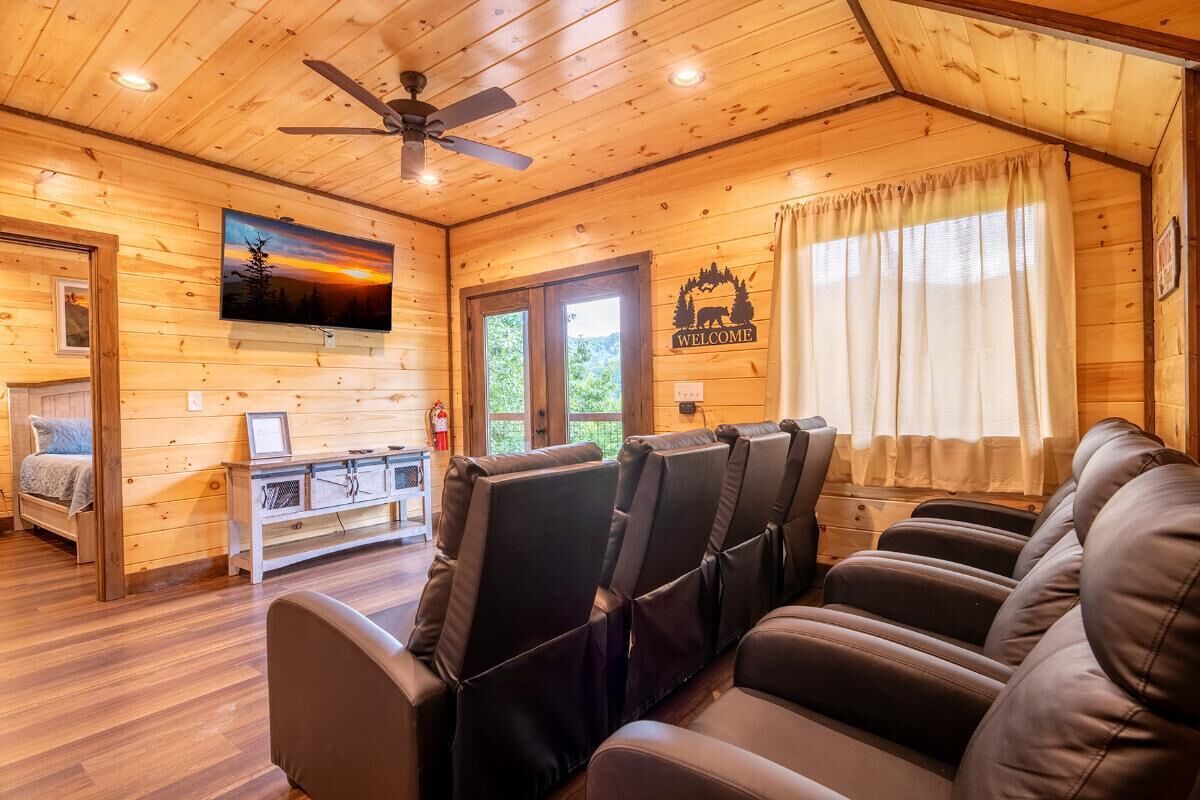 A wooden interior with a sofa, ceiling fan, and a 'WELCOME' sign.