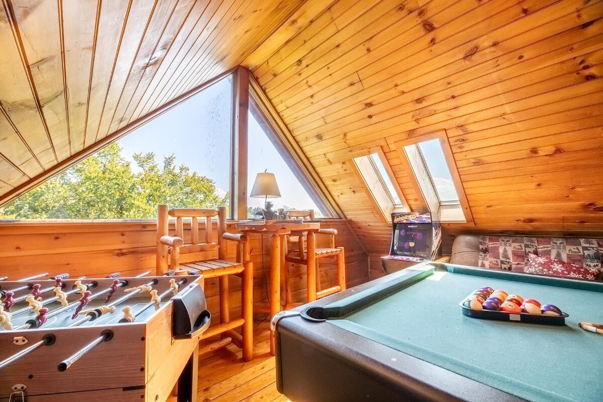 Ein gemütliches Zimmer mit Tischfußball, Billardtisch und Holzmöbeln.