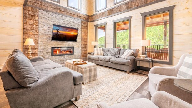 Una sala de estar acogedora con chimenea, asientos cómodos y ventanas amplias.