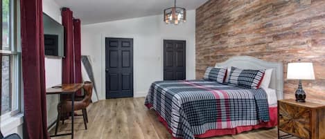 A bedroom with a bed, a desk, and a chair.