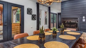 Comedor con una mesa larga, sillas y protectores de mesa decorativos.