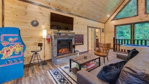 A wooden cabin interior with a fireplace, a pool table, and a cozy seating area. - Dreamcatcher Lodge (Sevierville)