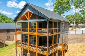 A two-story building with a balcony on the ground floor and a covered outdoor seating area. - Z - Hilltop Haven (Sevierville)