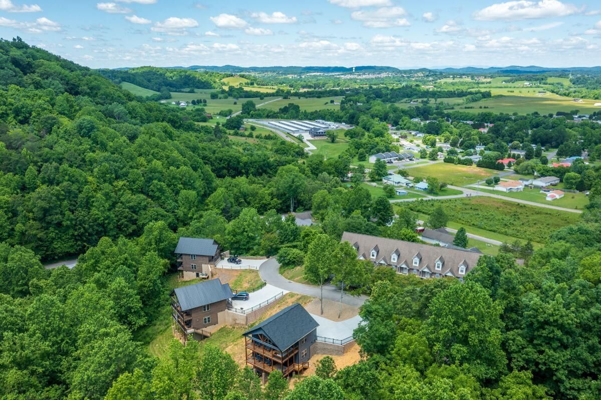 A residential area with houses, a large building complex, and surrounding greenery.