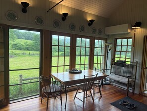 Ein Zimmer mit großem Fenster, einem Holztisch und einem Stuhl.