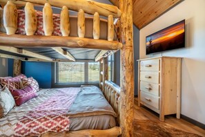 A bunk bed with a wooden headboard, a TV mounted on the wall, and a window with blinds. - Hochatime (Sevierville)