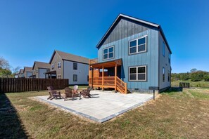 A two-story house with a patio area and outdoor seating. - Blue Bella (Sevierville)
