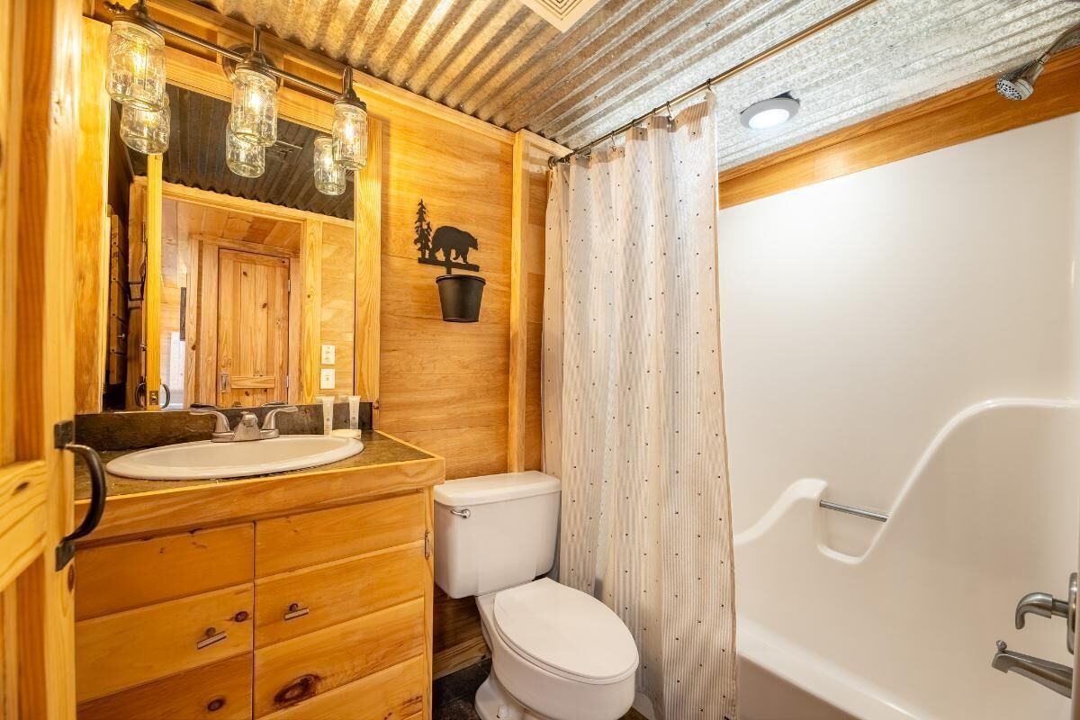 Ein Badezimmer aus Holz mit Waschbecken, Toilette und Badewanne.
