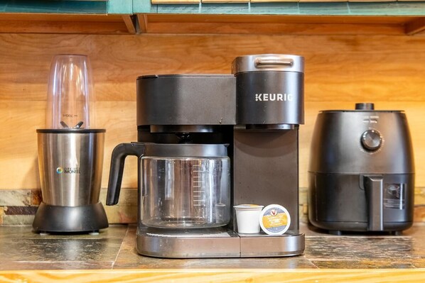 A coffee maker, a scale, and a vacuum cleaner on a kitchen counter. - Z - Black Bear Hideout (Gatlinburg)