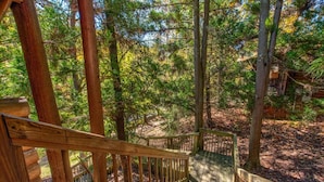 A wooden staircase leading to a cabin surrounded by trees. - Unforgettable Dreams (Sevierville)