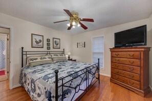 A bedroom with a bed, a ceiling fan, a dresser, and a television. - Z - Clear Fork Farm (Sevierville)