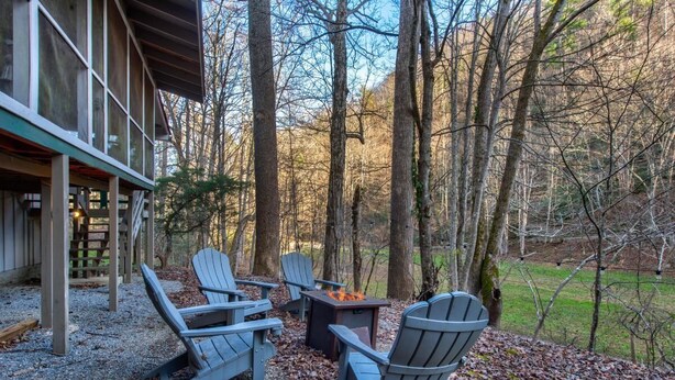 Eine Hütte mit Terrasse, Sitzgelegenheit im Freien und einem Feuerkorb.