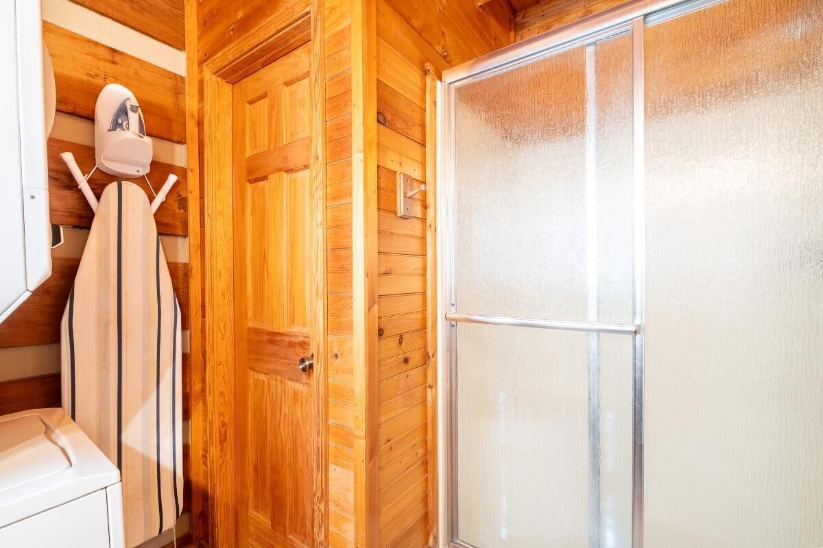 Un intérieur en bois avec un espace douche et un porte-serviettes.