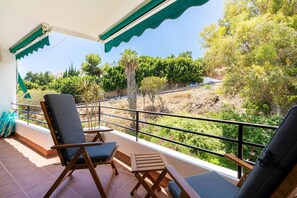 A balcony with a view of a dry landscape, a chair, and a small table. - Community Bahamas, 1 bedroom (Nerja)