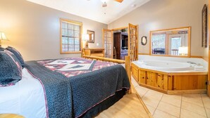 Un dormitorio con cama, un ventanal grande, ventilador de techo y un jacuzzi.
