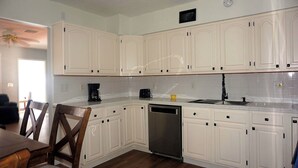 A kitchen with white cabinets, a dishwasher, a coffee maker, and a sink. - Modern Heart of Hollywood (Hollywood)