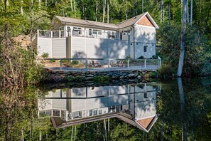 A cabin with a dock extending into a calm lake, surrounded by dense forest. - Private Pond, Mountain Escape (Highlands)