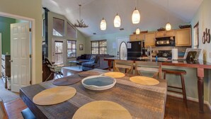 A spacious kitchen with wooden cabinets, a dining area with a large table, and a cozy living room with a sofa. - Blue Mist Vista (Gatlinburg)