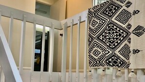 Eine Treppe mit weißer Geländer führt zu einer Erschließung im zweiten Obergeschoss, mit Küche und Essbereich.