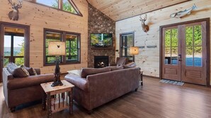 Ein gemütliches Blockhausschlafzimmer mit Kamin, Ledersofas und Holzwänden.