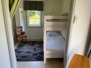 A bunk bed room with a window, a chair, and a patterned rug. - 4 Star Holiday Home in Onsala (Gottskar)