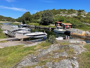 A marina with boats docked, a wooden pier, and a small red building. - 4 Star Holiday Home in Onsala (Gottskar)