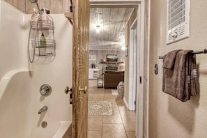 A bathroom with a bathtub, shower, and a towel rack. - Sleepy Bear (Sevierville)