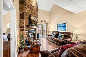 A cozy living room with a stone fireplace, leather sofas, and a Christmas tree. - My Happy Place (Gatlinburg)